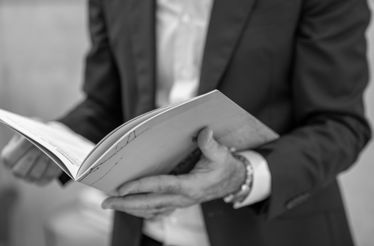 An executive reading through a document, held open in both hands.